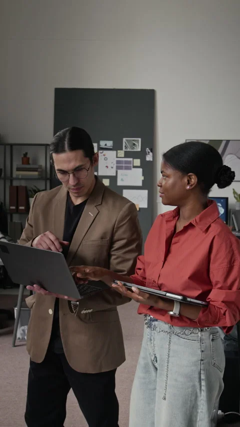 Vertical of Diverse Developers Collaborating on Laptop in Modern Office Stock Footage 336718781