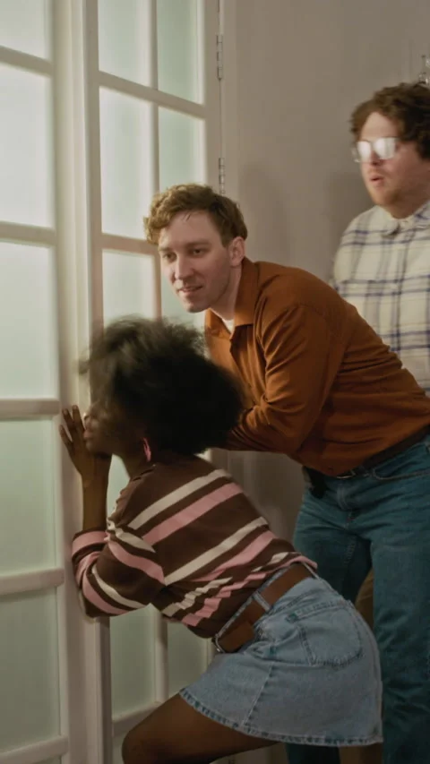 Vertical of Diverse Friends Getting Scared by Hand Shadow on Glass Door Stock-Footage 340272861