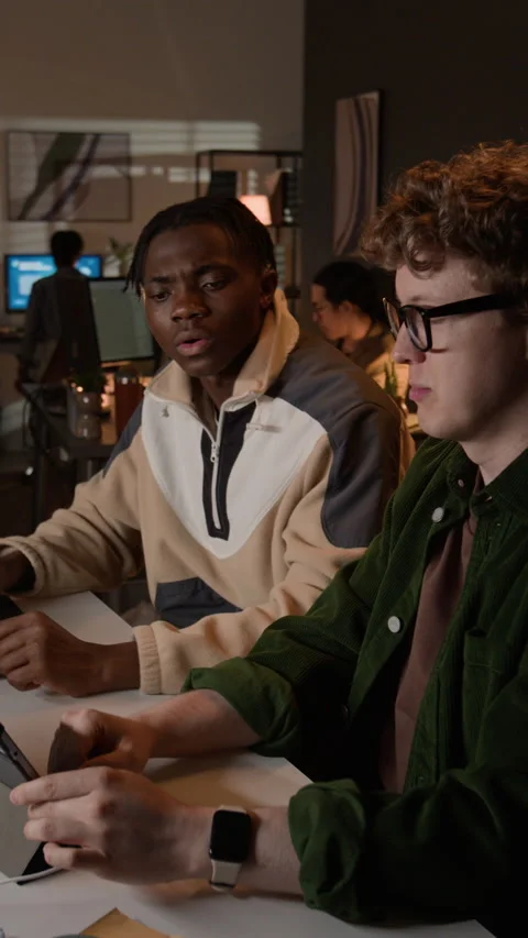 Vertical of Diverse Male Programmers Collaborating on Tablet in Office at Night Stock-Footage 336717112