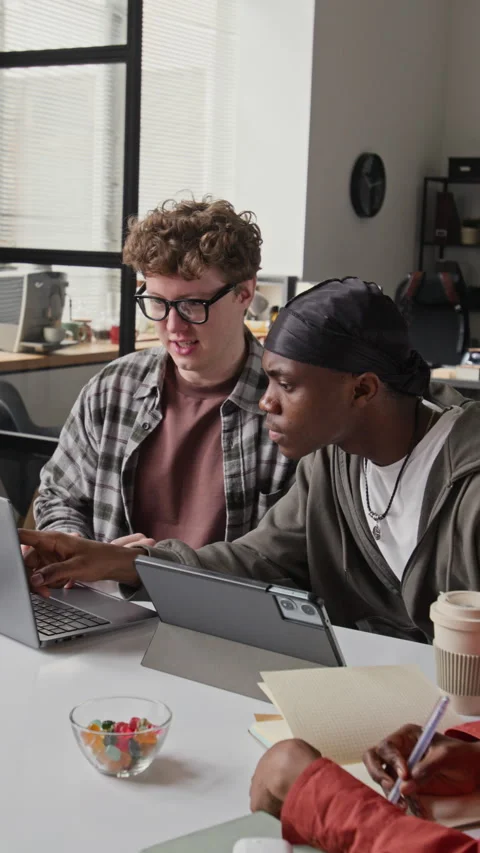 Vertical of Diverse Programmers Collaborating on Laptop and Tablet in Office Stock-Footage 336709036
