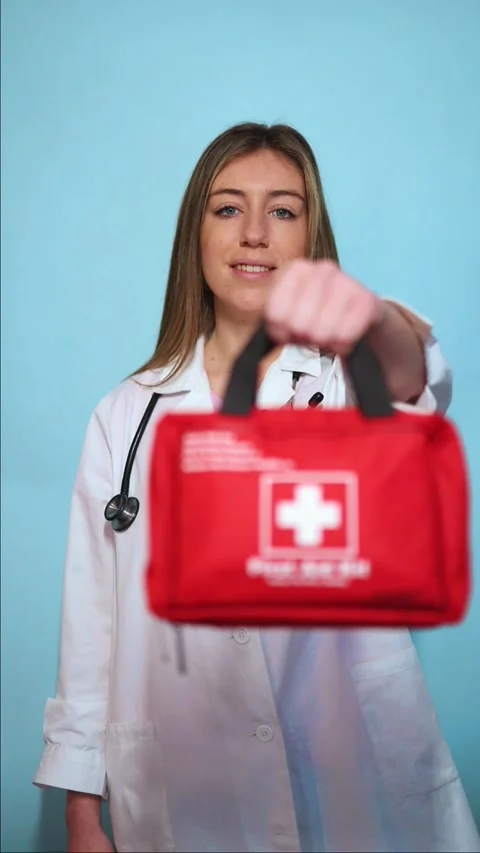 Vertical Doctor offering first aid kit on blue background Stock Footage 297675283
