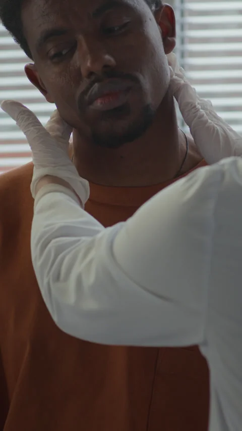 Vertical of Doctor Palpating Lymph Nodes of Male Patient in Clinic Stock Footage 299200771