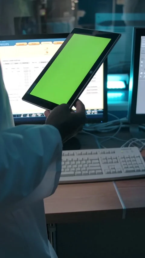 Vertical of Doctor with a tablet with a green screen watching the operation from Stock Footage 276749565