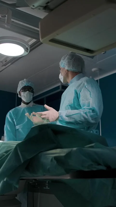 Vertical of Doctors examining patient and talking in operation room Stock Footage 276921587