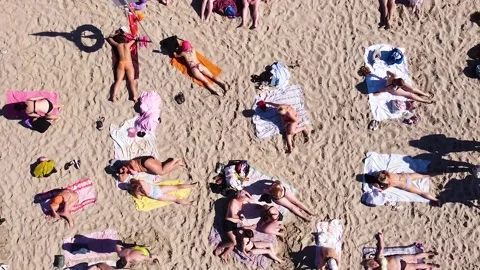 A vertical downward view from a drone of people relaxing on the beach Stockbeeldmateriaal 199238589