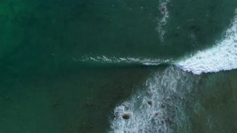 Vertical downward view of the ocean waves and surfer. Clean ocean water Stock Footage 153418417