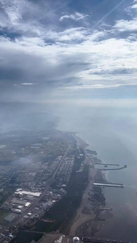 (Vertical) Dramatic Clouds Over the Taiwanese Coastline from an Airplane Window Stock Footage 341750438