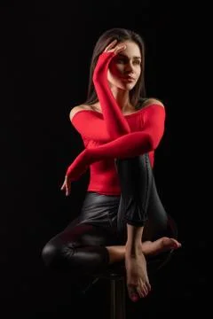 Vertical dramatic portrait with sensual brunette woman in red top with bared  Stock Photos