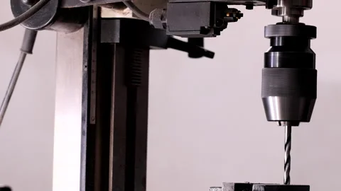 Vertical drilling machine in operation, showing the rotating drill moving up and Stock Footage 305173867