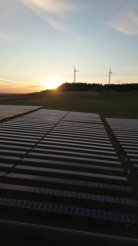 Vertical Drone Advancing Over Solar Panels Toward Wind Turbines Stock Footage 330051291