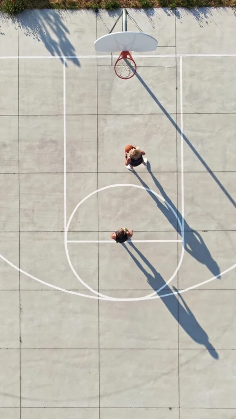Vertical Drone Aerial Shot of Two People Playing Pickup Basketball Stock Footage 342277722