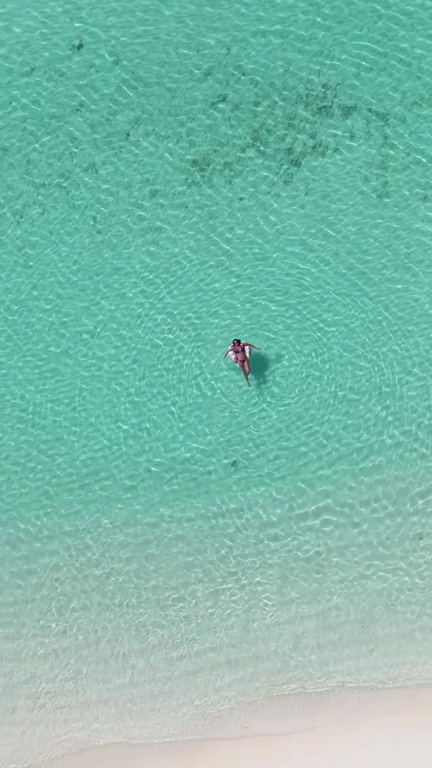 Vertical Drone Bird’s Eye View of Women Floating in Clear Maldives Lagoon 库存影片 331411501