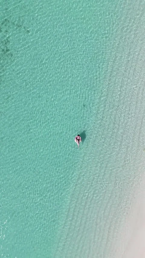 Vertical Drone Bird’s Eye View of Women Floating in Clear Maldives Lagoon 库存影片 331411674