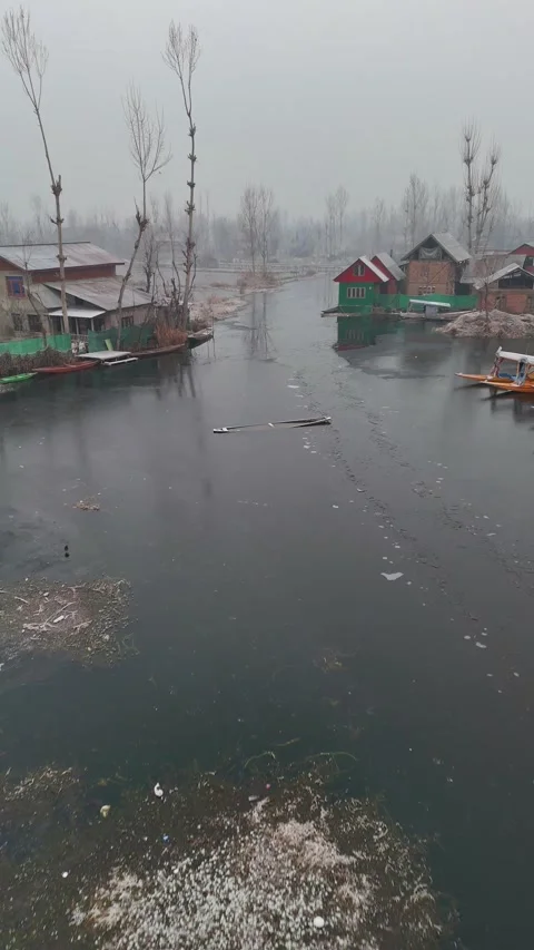 Vertical drone capturing Dal Lake’s frozen stillness, life paused by biting Stock Footage 311019707