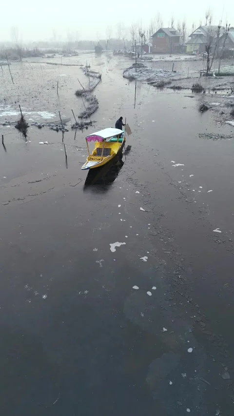 Vertical drone capturing the winter hustle of boatmen battling frozen pathways. Stock Footage 311019991
