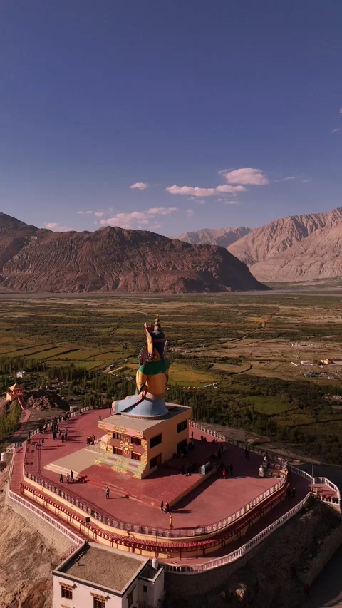 Vertical drone closing in on the golden face of the Diskit Maitreya statue. Stock Footage 310901081
