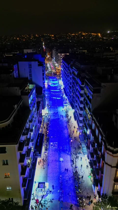 Vertical drone descending over city street with blue Christmas lights Stock Footage 345933061
