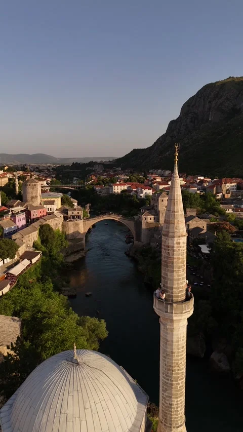 Vertical Drone Descent Past Mosque Minaret to Mostar Old Bridge Sunset 4K Stock Footage 337831234