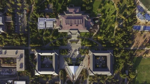 Vertical drone descent toward the main academic buildings and gardens of Stock Footage 332568489