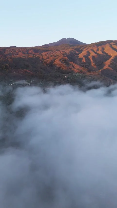 Vertical Drone Flight Above Clouds with Mountain Peaks at Sunset – 4K relaxing Stock Footage 314600592