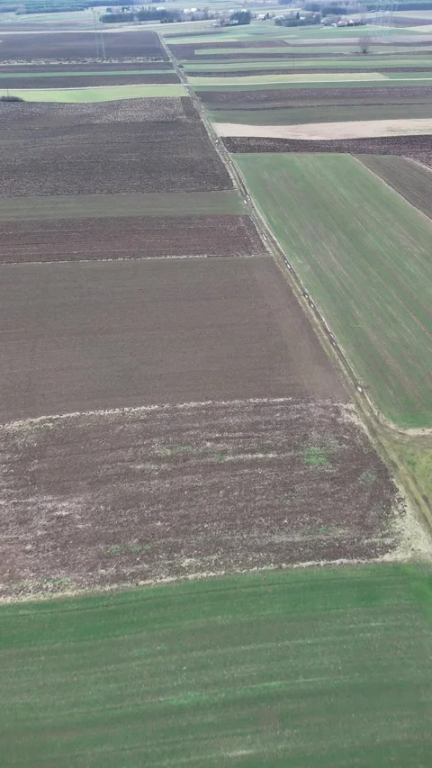 Vertical drone flight sideways over patchwork farmland showing cultivated fields Stock Footage 327385756