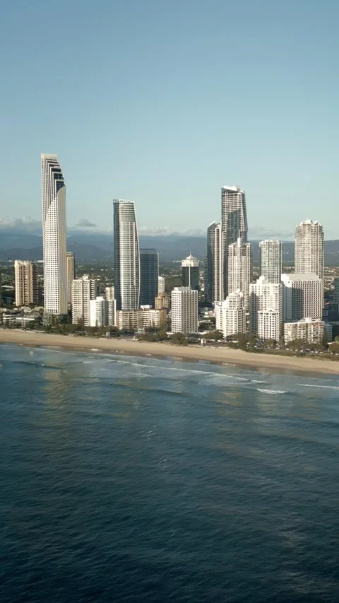 Vertical drone flying back revealing Surfers Paradise beach buildings waves Vidéo 328991170