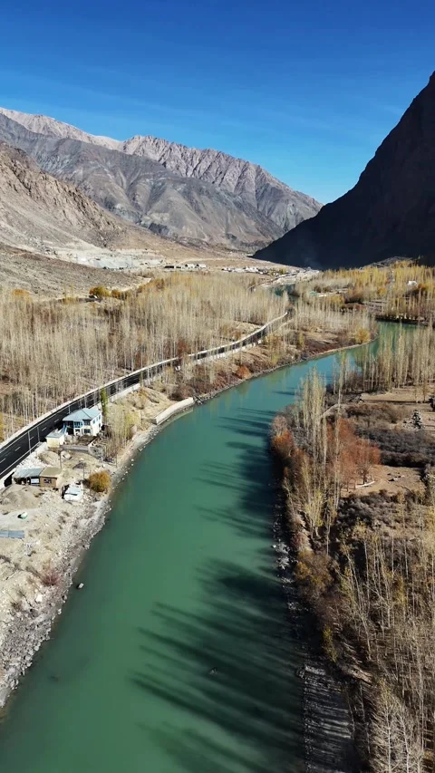 Vertical drone flyover of Suru Valley road journeying through fall hues. Stock Footage 310662372