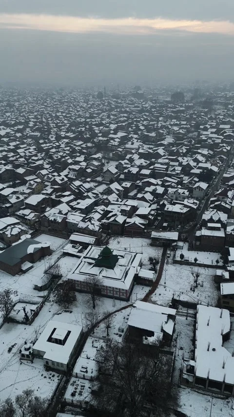 Vertical drone footage of breathtaking winter sunsets over a snow-covered city. Stock Footage 311021869