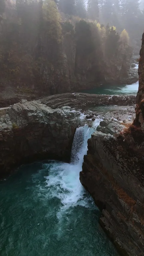 Vertical drone footage capturing the graceful curve around Aharbal, where water Stock Footage 311152210