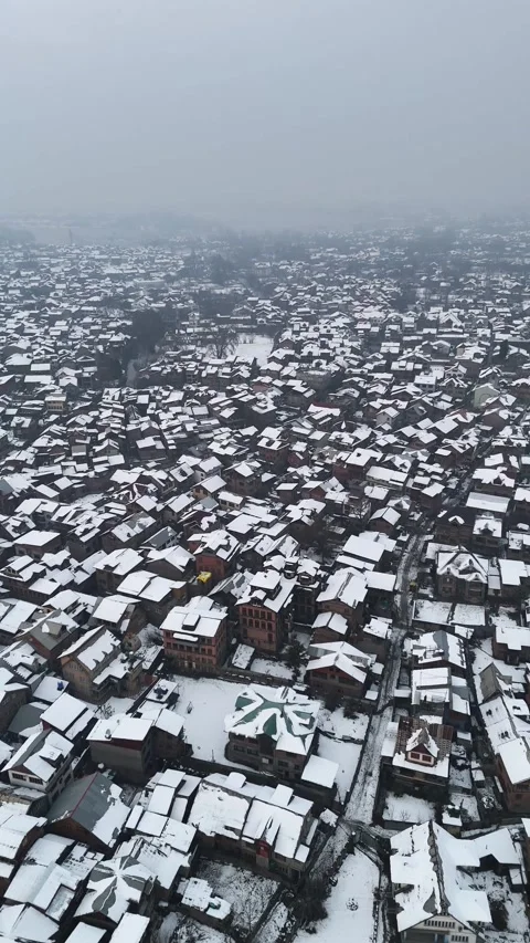 Vertical drone footage capturing Kashmir city blanketed in fresh snow. Stock Footage 311021465