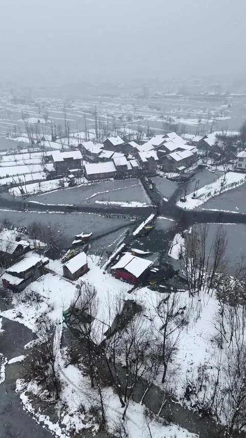 Vertical drone footage capturing the magical snow-covered ambiance of Dal Lake. Stock Footage 311021620