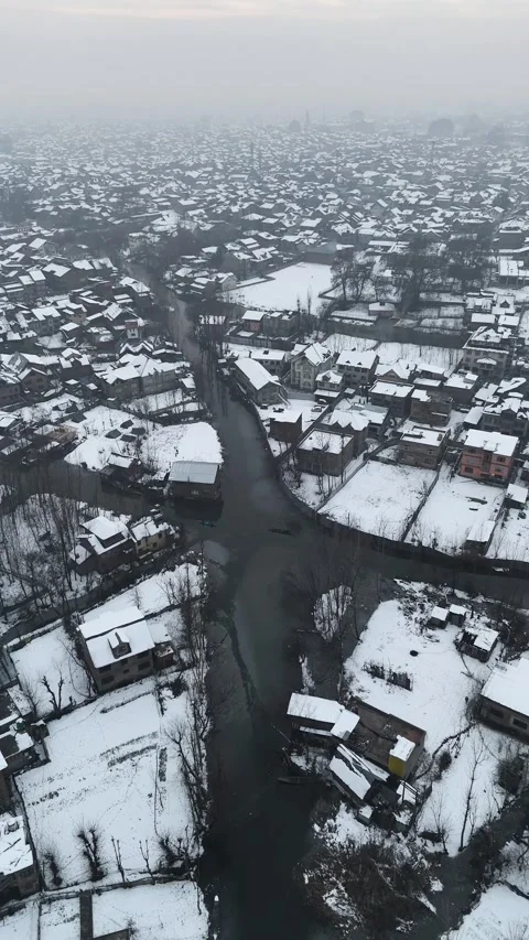 Vertical drone footage capturing the quiet beauty of snow-covered canals and Stock Footage 311021622