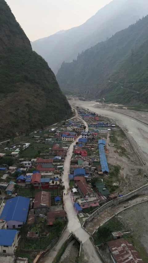 Vertical Drone footage capturing the simple charm of village life surrounded by Stock Footage 311019175