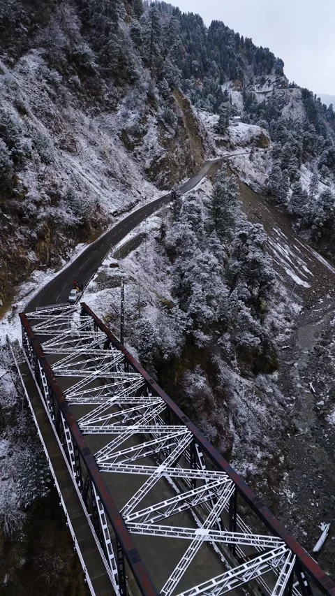 Vertical drone footage capturing the still beauty of a snow-covered bridge on a Stock Footage 311151705