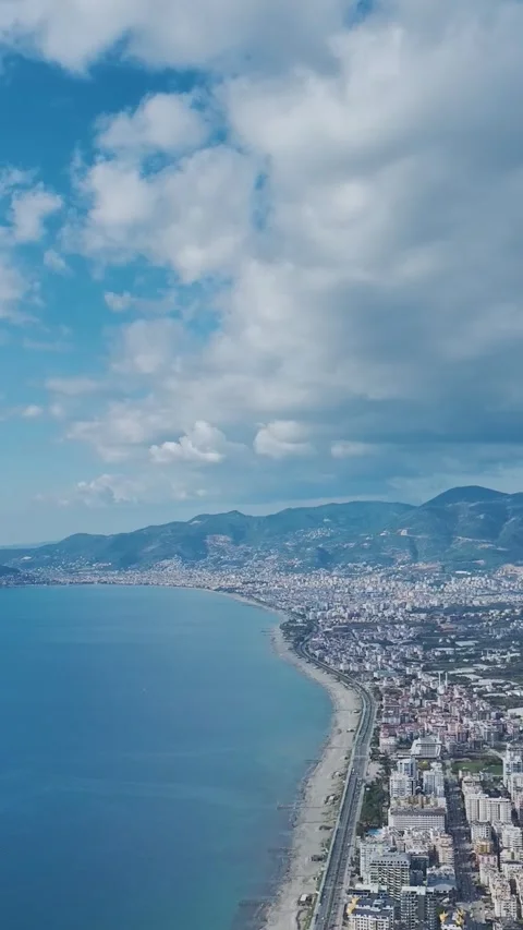 Vertical drone footage of coastline with reef edge and waves breaking on shore 库存影片 341872245