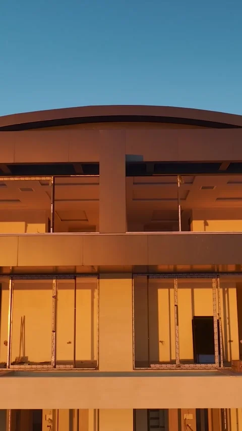 Vertical drone footage of construction facade with metal details and stacked Stock Footage 341876691