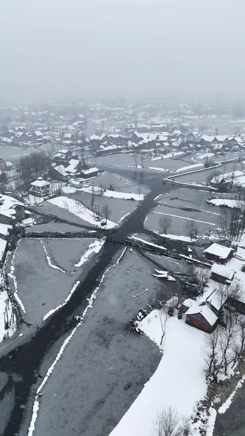Vertical drone footage of Dal Lake’s interiors gently covered by falling snow. Stock Footage 311021724