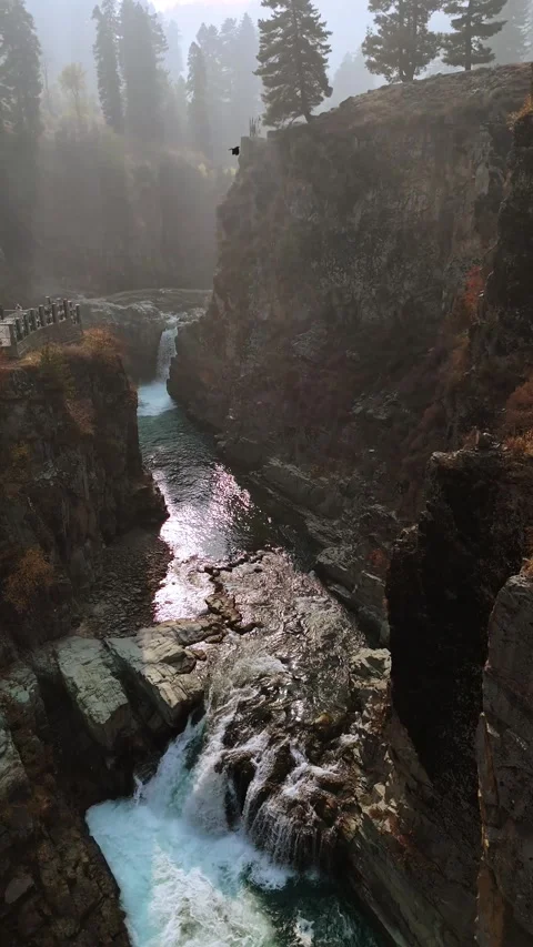 Vertical drone footage flowing from the mighty waterfall to the calming stream — Stock Footage 311152249