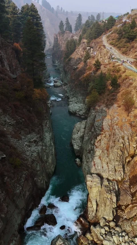 Vertical drone footage gliding over the water’s path as it gracefully leaves the Stock Footage 311152100