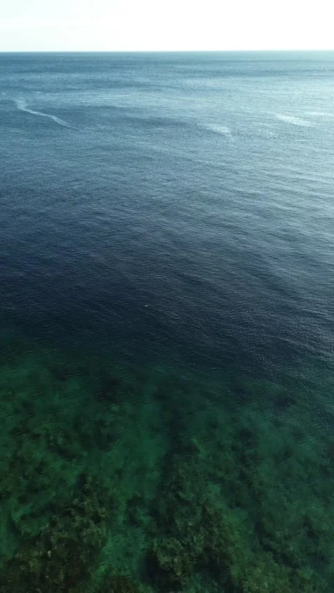 Vertical Drone Footage of Over Blue Sea with Sunlight and Blue Sky Stock-Footage 266979960