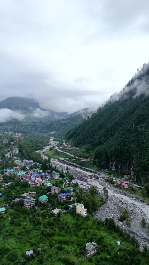 Vertical drone footage of rain clouds hovering above remote hillside homes. Stock Footage 310659343