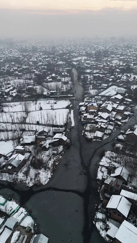 Vertical drone footage of small icy canals snaking through Srinagar’s Stock Footage 311021621