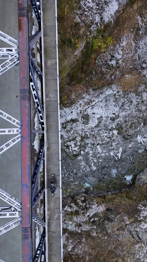 Vertical drone footage of a top down shot as a rider moves over a snow-packed Stock Footage 311151038