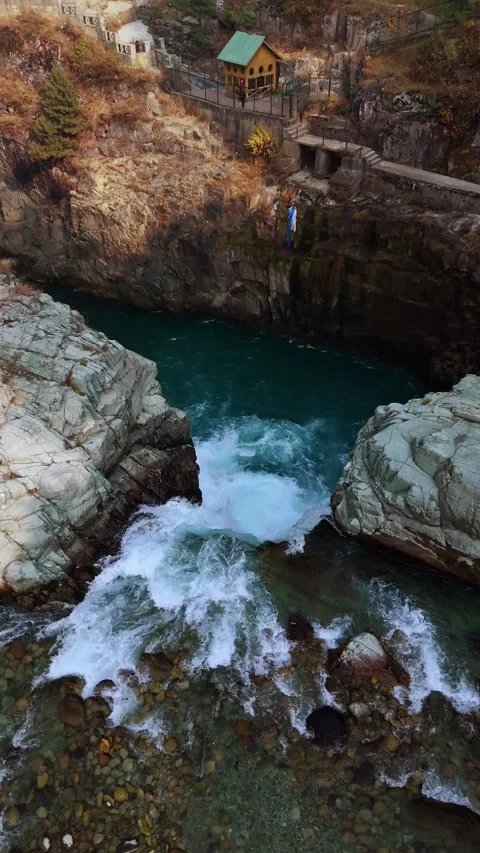 Vertical drone footage top-down shot where the waterfall meets the stones, Stock Footage 311151820
