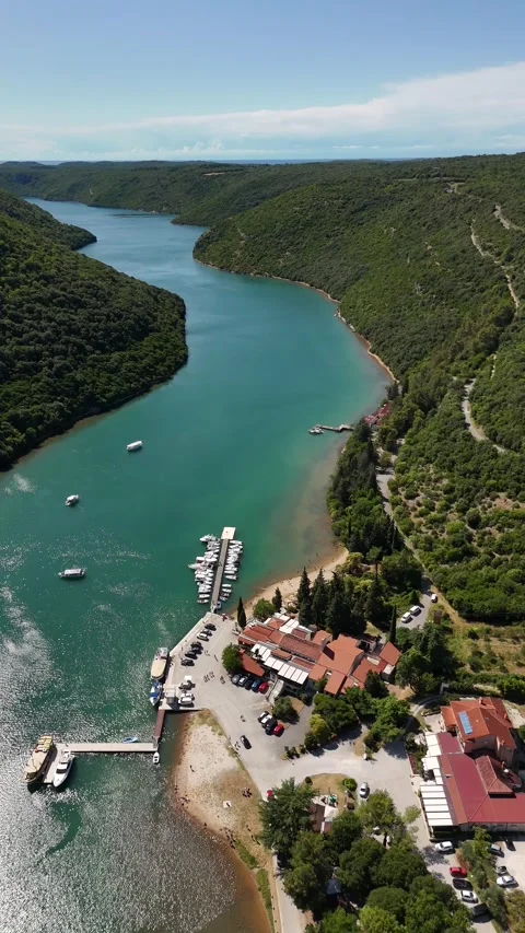 Vertical drone glide over a scenic bay between lush coastal hills Stock Footage 322045068