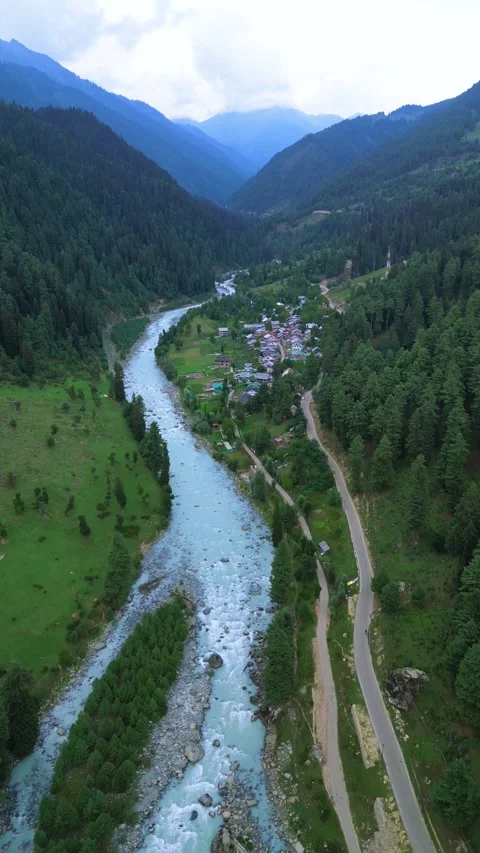 Vertical drone gliding through cloud shadows over Pahalgam. Stock Footage 310806600