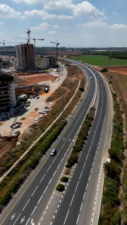 Vertical Drone Hover Over Highway Between Open Fields and Residential Stockbeeldmateriaal 339136318