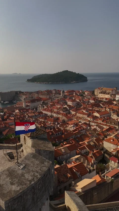 Vertical Drone Orbit of Dubrovnik Old Town Roofs with Corner Waving Flag 4K Vídeo Stock 337849104