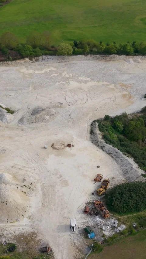 Vertical drone orbit over sand and gravel quarry in Essendon, showing aggregate 動画素材 334657849