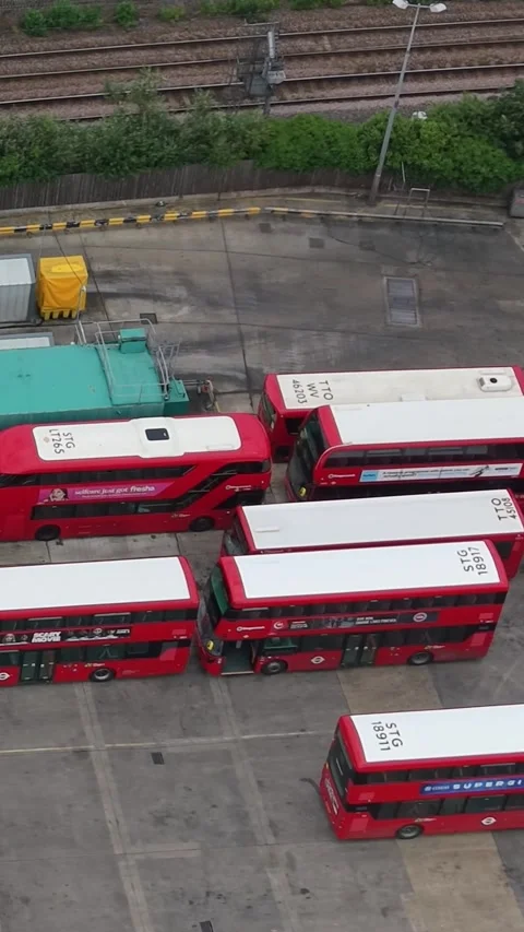 Vertical drone pan over Lea Interchange bus garage with parked London double Stock Footage 337866140